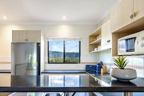 The kitchen is well-equipped with everything needed to cook your own meals with views facing the mountains
