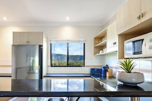 The kitchen is well-equipped with everything needed to cook your own meals with views facing the mountains