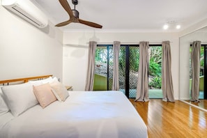 The first bedroom on the second level features a queen-size bed, ensuite bathroom, built-in robes and a private patio that adjoins the parkland.