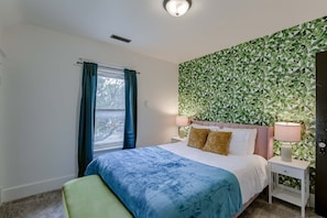 Bedroom with plush beddings and windows