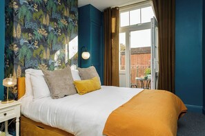 Charming Bedroom: Vibrant decor, sunlight streaming in, and a lovely balcony for morning coffee!