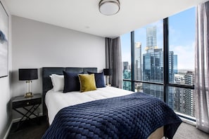 In the second bedroom, take in sweeping, floor-to-ceiling views overlooking the city from your queen-size bed.  
