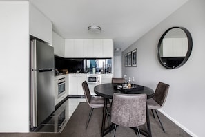 The open-plan kitchen and dining area includes a four-seater table where you can dine at home.