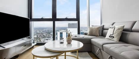 The open plan living room is framed by full height windows, capturing spectacular vistas across the city skyline.