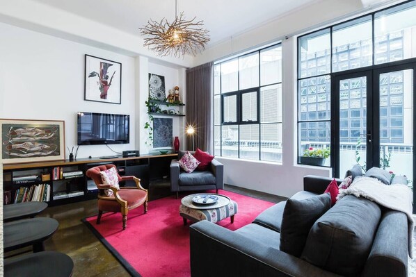 Framed by crittall style windows overlooking Flinders Lane, the designer lounge room is the perfect spot to kick back and watch some TV.