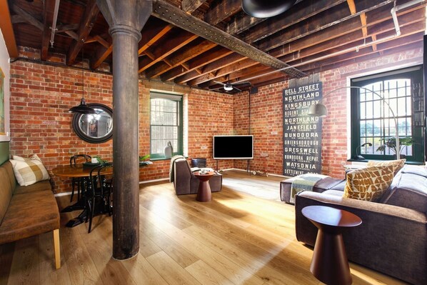 Defined by ornate brickwork, exposed ceilings and rustic timber, the open plan living area oozes industrial style with retro touches.