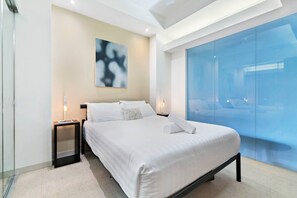 The bedroom offers a plush queen bed, abstract art and plenty of storage space.