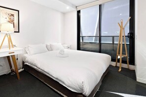 The second bedroom offers a plush queen bed and direct access to the private balcony.
