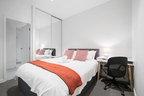 The main bedroom features a queen bed and dedicated workspace.