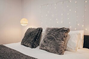 The cosy bedroom sleeps two in a queen bed under fairy lights, creating a cosy and tranquil space to get some shut eye.