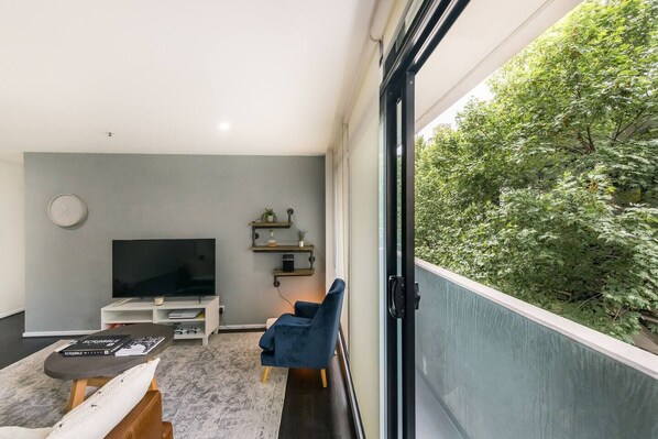 Open plan living and dining flows out to the narrow private patio with leafy views. Open the sliding doors and allow the breeze to roll in.