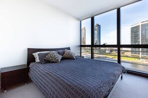 The master bedroom features a plush queen bed, where you can relax and enjoy views of the Yarra River below.