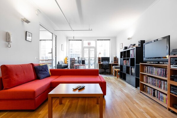 A bright red L-shaped couch offers a comfortable spot to cosy up with a good movie from our DVD collection.