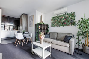 The living area seamlessly flows into the open-plan dining area and kitchen, creating a harmonious living space.