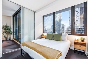 The queen-sized first bedroom reveals glimpses across the skyline and comes set with side tables and reading lights.