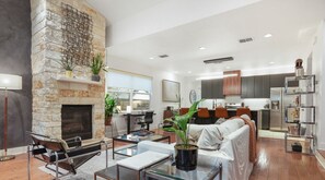 Large open living room with sofa, smart tv, conversational seating, dining and kitchen with island