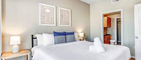 King bed with custom hotel quality linens and on bathroom