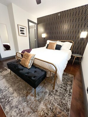 
Indulge in luxury at our tranquil retreat, where neutral tones create a serene ambiance. Enjoy the comfort of plush textures—soft sheets, a cozy bed, stylish wallpaper, and a full-length mirror. This chic escape offers the perfect blend of modern elegance and relaxation.