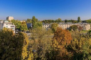 A view from the apartment showcasing a lush green park and the city skyline in the background.
