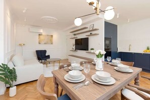 A small dining area set up with four plates and glasses, featuring a wooden dining table and upholstered chairs. The setup is cozy and inviting.