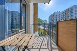 Spacious balcony with outdoor furniture. 