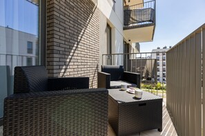 An outdoor balcony area with wicker furniture, showcasing a private terrace perfect for relaxation or entertaining guests.