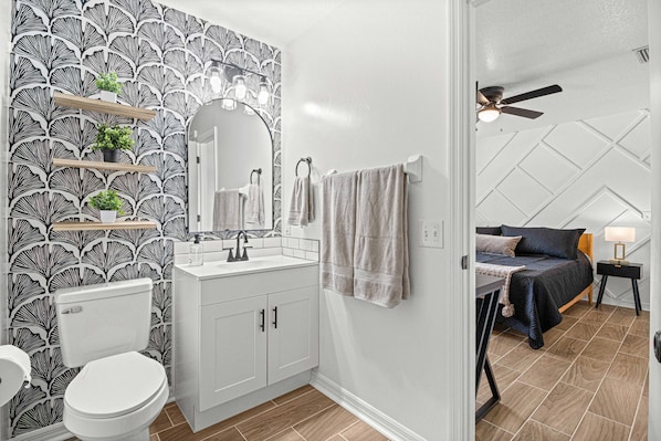 Primary bathroom with walk-in shower and primary bedroom. 