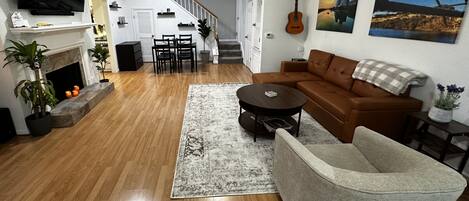 Spacious living room with sofa sleeper, chairs, fireplace, pop up laptop table. 