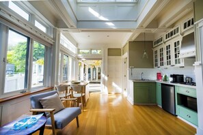 An elegant and fully-equipped kitchen has appliances including a stovetop, microwave, and small bar fridge.