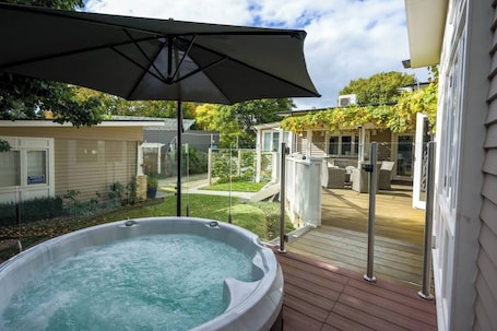 The shared outdoor deck offers a tranquil hot tub where you can spend morning, afternoons or evenings truly relaxing .