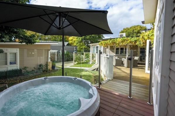 The shared outdoor deck offers a tranquil hot tub where you can spend morning, afternoons or evenings truly relaxing .