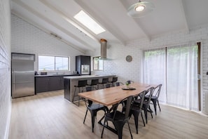 A spacious dining table and breakfast bar encourage guests to come together throughout the day.
