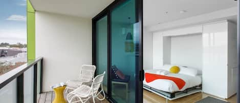 Sliding glass doors open from the studio out to the private balcony.
