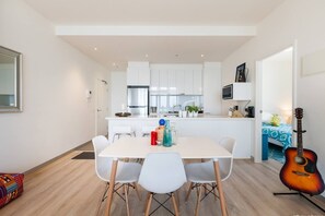 Open plan living flows to the dining area and modern kitchen with an oversized island and benchtop seating.