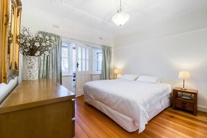 The first bedroom is spacious, offering access to the enclosed balcony and featuring a plush king bed, plus plenty of storage for your belongings.