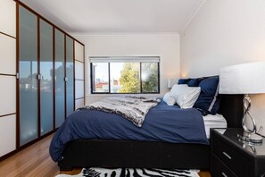 The master features plenty of storage, with skyline views visible from the plush queen bed.