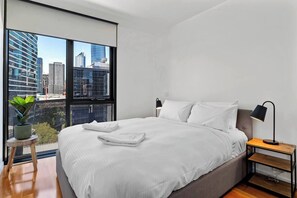 The second bedroom offers a queen-size bed with side tables and reading lamps. 

