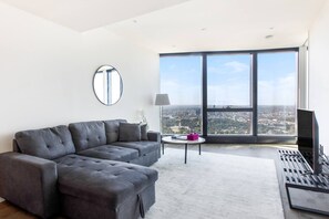  Relax on the sofa and chaise with a movie in the living area, where floor-to-ceiling windows offer sweeping views of the city and bay.  
