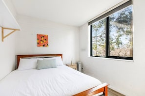The first bedroom highlights a queen-sized bed and has a nice leafy outlook.
