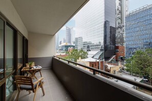 A spacious, private balcony features a table for two with city views.