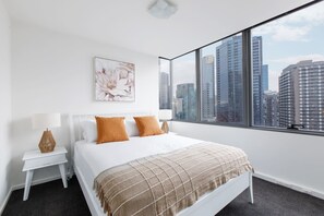 The views continue in the second bedroom which includes a queen-size bed with side tables and reading lamps.