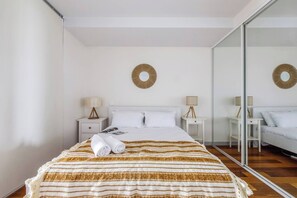 Retreat to the bedroom area with a queen-sized bed and built-in wardrobes with floor-to-ceiling mirrors. 
