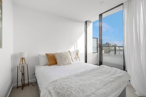 The bright second bedroom comes with a queen-sized bed and opens to the balcony.