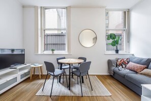 The open-plan living area offers a four-seater dining table to enjoy your meals.
