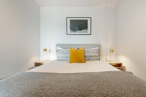 The bedroom features a queen bed dressed in quality linen and in-built, mirrored wardrobes for convenience.