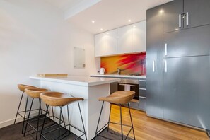  The streamlined kitchen includes all you need to cook up some fresh produce from nearby Prahran Market, with seating available at the breakfast bar. 

