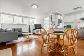 Dine indoors at the timber dining table that can fit up to four guests and sits near the kitchen and living area
