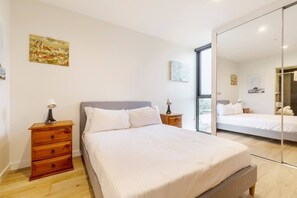 The first bedroom features a double bed, generous wardrobe space with full-length mirrors, and a full ensuite