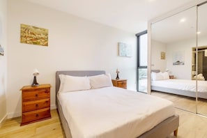 The first bedroom features a double bed, generous wardrobe space with full-length mirrors, and a full ensuite