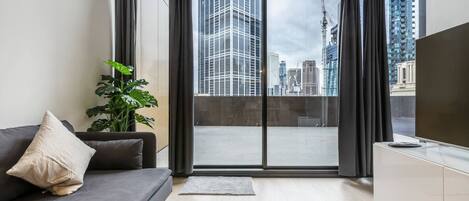 The apartment sits against a backdrop of the city that can be seen through the huge, floor-to-ceiling windows that frame the space